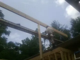 Carpenter setting a ridge beam over a new addition frame — Ice Dam Removal by Roofing Brothers in Wrightstown