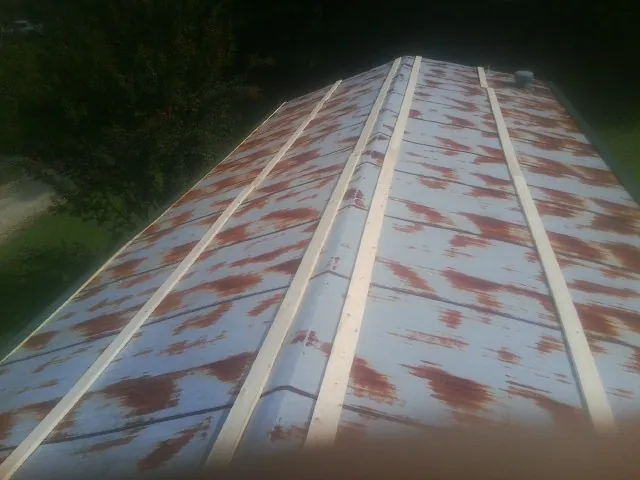 Rusted metal roof panels with new wood purlins before replacement — Storm Damage Roof Repair in Wrightstown by Roofing Brothers