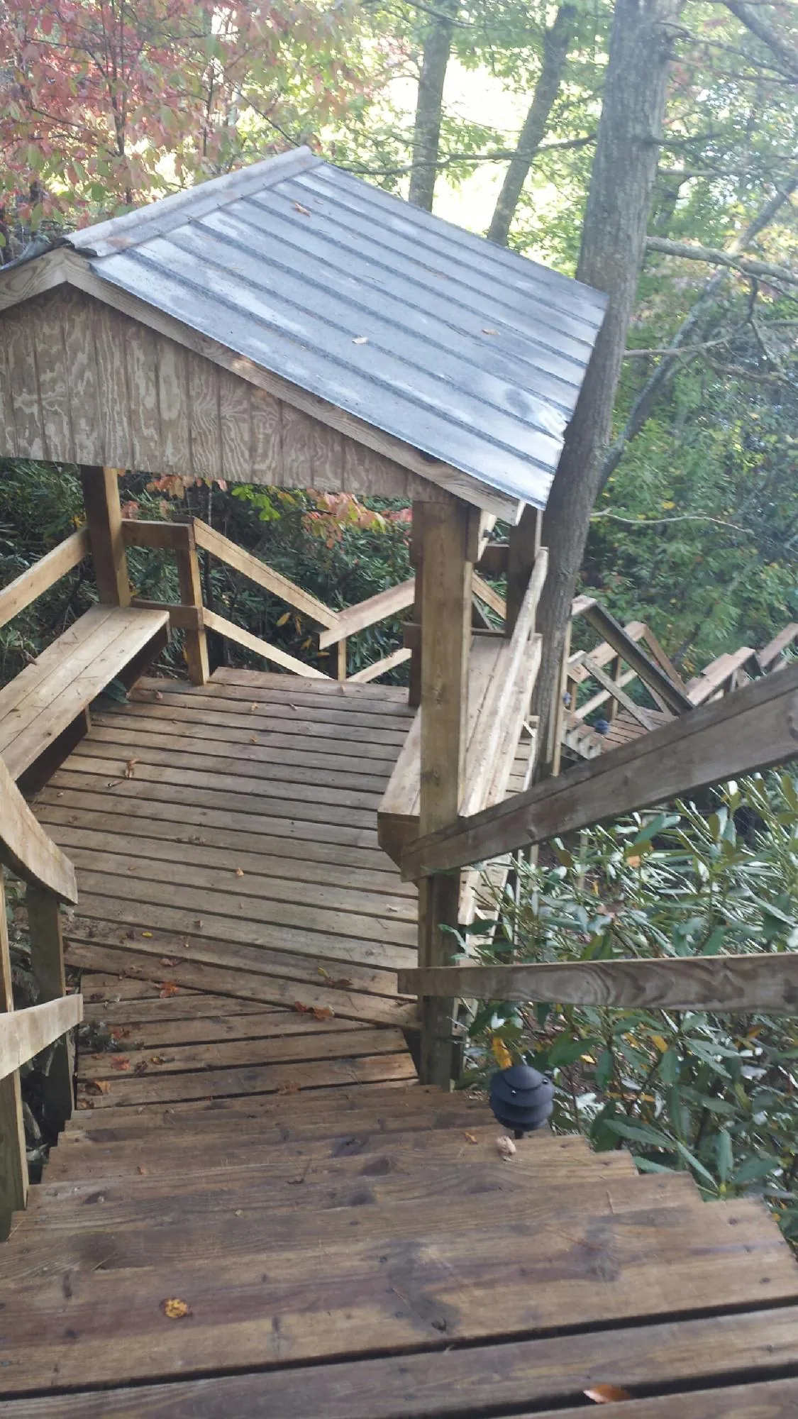 Metal roofed shelter over wooden steps on a wooded walkway — Skylight Repair & Installation work by our crew in Wrightstown